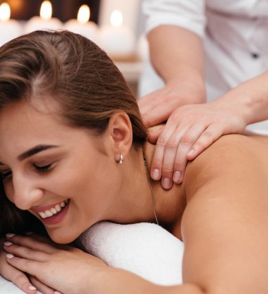 Masseur doing massage the head of an adult woman in the spa salon